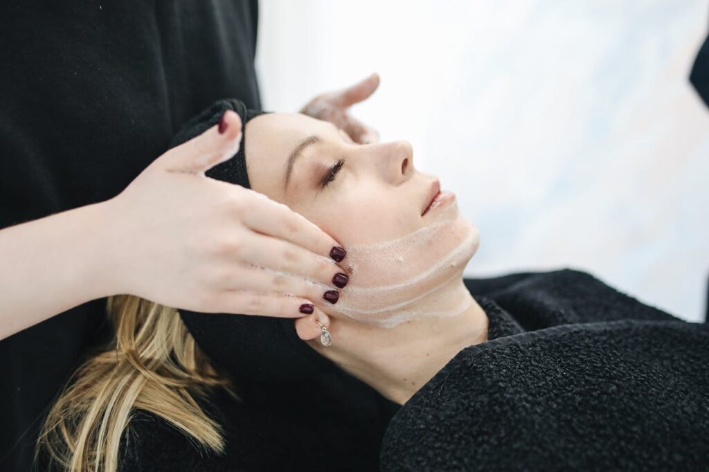 Side view of a woman receiving a soothing facial treatment at a spa, promoting wellness and skincare.